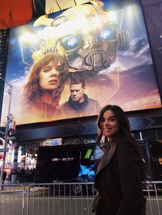 a woman standing in front of a movie poster