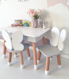 a child's table and two chairs with flowers on top