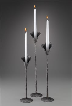 three candles are sitting next to each other on a gray surface with one candle in the middle