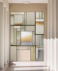 a large window with many different colored glass panels on the side of it in a room