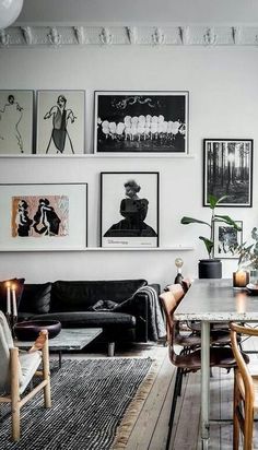 a living room filled with lots of furniture and pictures on the wall above it's coffee table