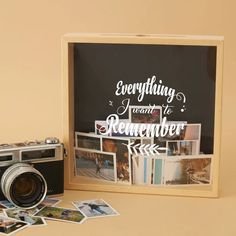 an old camera sitting next to a sign and some pictures on the table with it