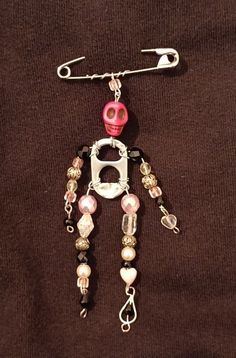 a pink and white beaded robot necklace on a brown shirt with silver chain attached to it