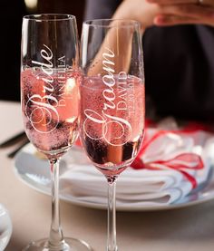 two wine glasses with pink liquid sitting on top of a table