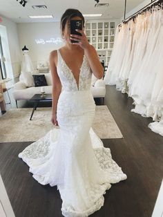 a woman is taking a selfie in her wedding dress while looking at her phone