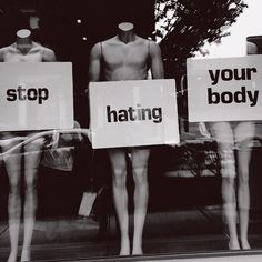 three mannequins holding signs that say stop, your body and hating in front of a store window