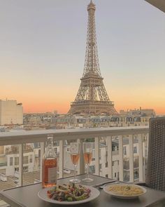 two plates of food on a table in front of the eiffel tower