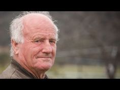 an older man with white hair is looking at the camera