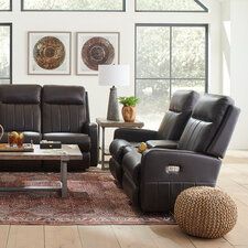 a living room with two recliners and a coffee table in front of windows