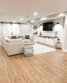 a living room filled with furniture and a flat screen tv mounted to the side of a wall