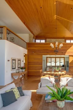 a living room filled with lots of furniture and a large wooden ceiling mounted to the side of a wall