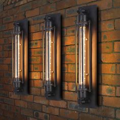 three light fixtures mounted on the side of a brick wall