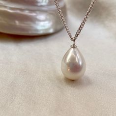 A stunning single pearl pendant necklace, on a sterling silver chain. * 13mm x 10mm teardrop freshwater pearl  * 16"/40cm fine sterling silver chain (not your length? message me) * boltring clasp * classic minimalist design  A truly beautiful white freshwater pearl with natural pink colours in its fabulous lustre. This perfect teardrop shaped pearl has natural banding which only adds to its unique allure.  Hanging from a recycled sterling silver curb chain, this pearl pendant necklace is perfect Pearl Wedding Anniversary Gifts, Unique Pearl Jewelry, Single Pearl Pendant, Pearl Necklace Bridal, Large Pendant Necklace, Single Pearl, Classic Brides, Necklace Bridal, White Freshwater Pearl