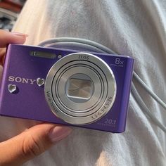 a person holding a purple camera in their hand