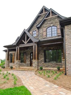 a large brick house with lots of windows and stone walkway leading to the front door