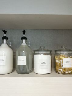 three jars with labels on them are sitting on a shelf