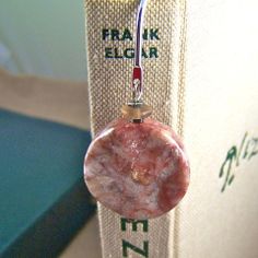 a book with a pink marble bead hanging from it's cover