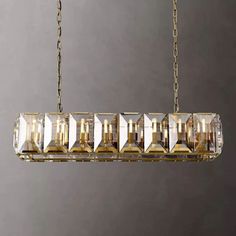 a chandelier hanging from a chain with crystal cubes in the center and bottom