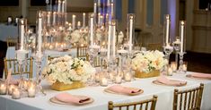 a table topped with lots of white flowers and candles