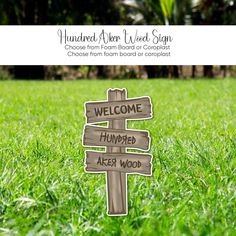 a wooden sign sitting on top of a lush green field