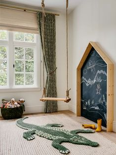 a child's room with a chalkboard in the corner and toys on the floor