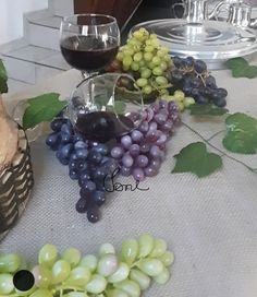 a table topped with grapes and wine glasses