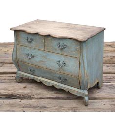 an old blue dresser is sitting on some wood