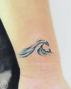 a blue wave tattoo on the wrist is shown in this image, it looks like an ocean wave