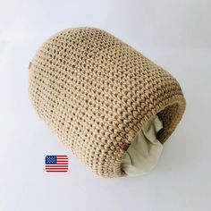 a crocheted beanie hat with an american flag sticker on the side