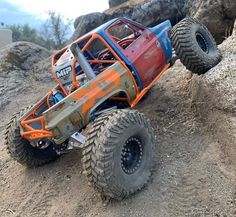 an orange and blue monster truck on top of a hill