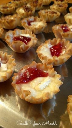 small pastries with jam on them sitting on a metal tray, ready to be eaten