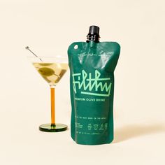 a drink in a glass next to a green bag