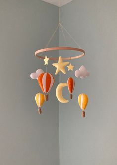 a crib mobile with hot air balloons, stars and crescents hanging from the ceiling