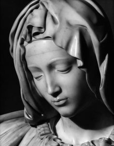 a statue of the virgin mary is shown in this black and white photo, it appears to be wearing a headdress