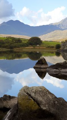 a lake surrounded by mountains with a quote about snowdonia is one of the uk's finest natural treasures