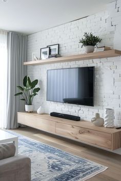 a living room with white brick walls and wooden shelves on either side of the tv