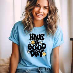 Spread joy and positivity wherever you go with our "Have a Good Day" unisex t-shirt! 🌼😊 Featuring cute bubbly text adorned with daisies and smiley faces, this tee is guaranteed to lift your spirits and brighten your day. Get ready to spread good vibes and smiles with every wear! 🌈 Happy Vibes: Embrace the power of positivity with our cheerful tee! The playful design and uplifting message are sure to put a smile on your face and the faces of those around you. It's like wearing a ray of sunshin Fun Slogan T-shirt For Everyday, Cute Everyday T-shirt With Slogan, Inspirational Everyday T-shirt With Graphic Print, Cute Slogan T-shirt For Everyday, Cute Everyday T-shirt With Letter Print, Smiley Daisy, Positive Tees, Smiley Faces, Good Cheer