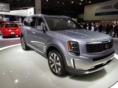 a silver suv is on display at an auto show with other cars in the background