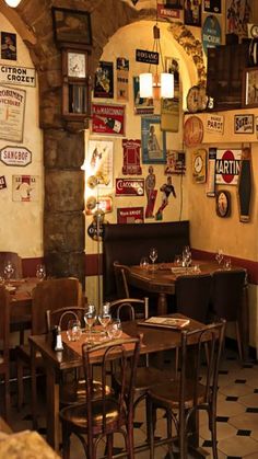 the interior of a restaurant with tables, chairs and signs on the wall above them