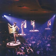 several mannequins are displayed on stage in front of an audience