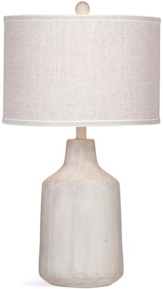 a white table lamp with a beige shade on the base and a light bulb at the end