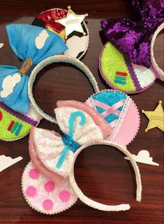 several minnie mouse ears are laying on a table next to some other headbands