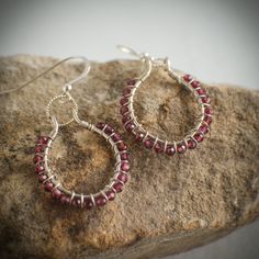 Garnet and sterling silver hoop earrings.  This listing features a pair of sterling hoops that were hand formed and lightly hammered.  Each hoop was wrapped with 21 genuine 3mm garnet beads.  Each hoop dangles from a sparkling twisted soldered sterling silver jump ring and sterling silver ear wire.  Each earring is a little over 1 inch in diameter and dangles just about 1.5 inches from the earlobe.  Very lightweight and easy to wear. These earrings will arrive boxed and ready for gift giving.  O Red Sterling Silver Wire Wrapped Earrings, Nickel Free Oval Hoop Earrings Gift, Oval Nickel-free Hoop Earrings Gift, Red Sterling Silver Hoop Earrings, Red Sterling Silver Round Hoop Earrings, Red Gemstone Hoop Earrings, Sterling Silver Hoop Jewelry Gift, Sterling Silver Hoop Jewelry As Gift, Sterling Silver Hoop Jewelry For Gifts