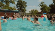 many people are in the pool playing with beach balls