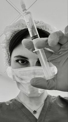 a woman in scrubs holds up a syosher to her face