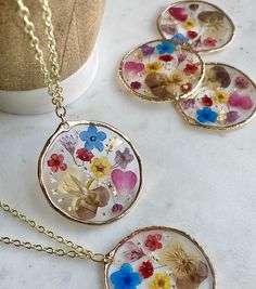 Oh wildflowers 🌸 is there anything better? This big circular pendant is made of real pressed flowers preserved into resin. There is gold leafing sprinkled into the resin to make the pendant really sparkle ✨This is made to last a long time and the high quality resin preserves the flowers to stay at this vibrancy for as long as the necklace lasts! The pendant is on a super long 28 inch chain with NO clasp. You can easily slip this over your head without having to mess with the closure in the back Gold Resin Nature-inspired Jewelry, Nature-inspired Gold Resin Jewelry, Bohemian Jewelry With Pressed Flowers In Resin, Gold Floral Resin Jewelry, Botanical Style Gold Resin Jewelry, Bohemian Gold Resin Necklace, Resin Necklace With Pressed Flower Pendant, Resin Necklace With Pressed Flowers In Round Pendant, Round Resin Pendant Necklace With Pressed Flowers