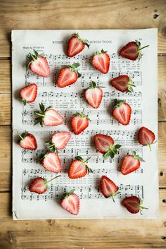 strawberries are arranged on top of sheet music