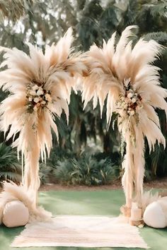 an outdoor ceremony with pamolite and feathers on the aisle, surrounded by palm trees