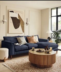 a living room with a blue couch and coffee table in front of a large window