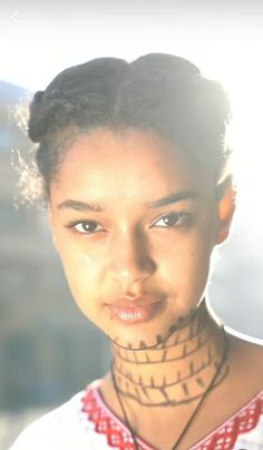 a woman with tattoos on her neck and chest